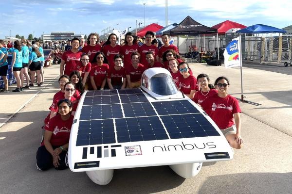The MIT Solar Electric Vehicle Team poses with Nimbus, their solar car.