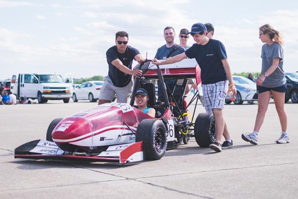 Cheyenne Hua ’19 (seated) served as captain of MIT Motorsports during her time as an undergraduate. She now works at SpaceX as a structures engineer.